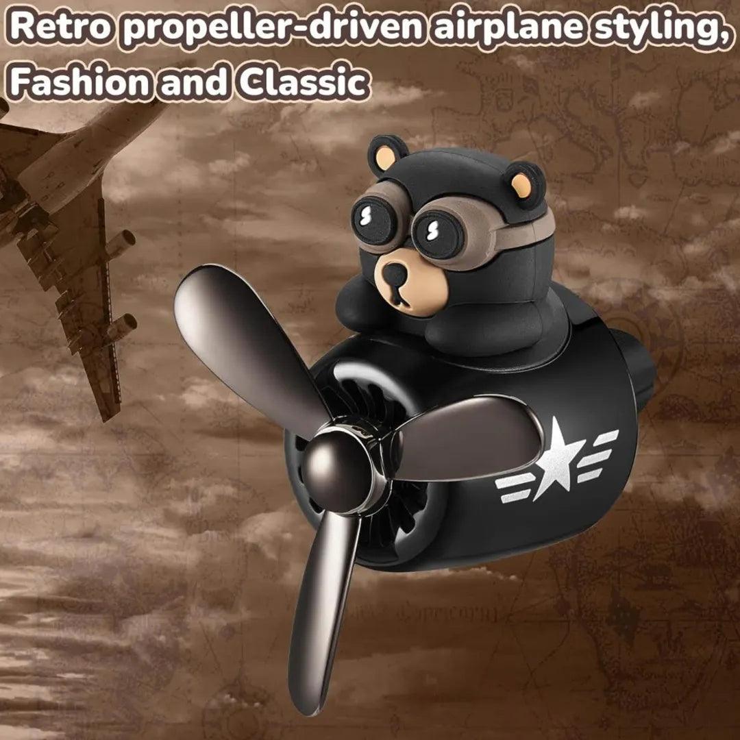 Bear pilot-themed car air freshener with retro propeller-driven airplane styling, combining fashion and classic elements.
