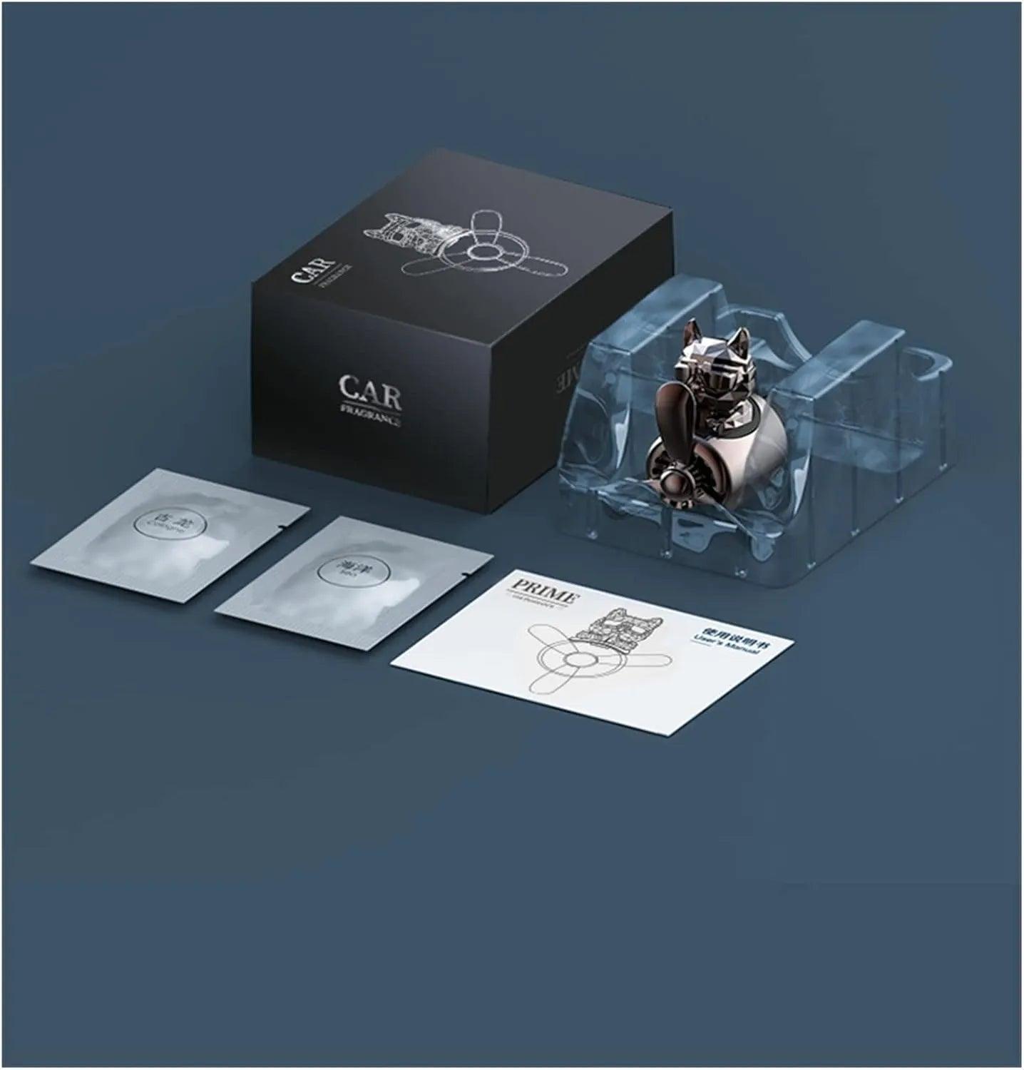 The image shows a car air freshener set featuring a bulldog-shaped air freshener with a propeller design. The set includes the bulldog air freshener, which is packaged in a clear plastic holder, two fragrance packets, and an instruction manual. The packaging box is black with a minimalist design and the words "CAR FRAGRANCE" printed on it.