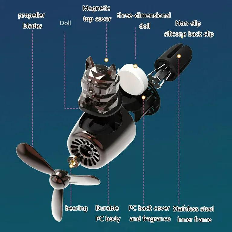 The image shows an exploded view of a bulldog pilot car air freshener with a propeller design, detailing its components. The labeled parts include: Propeller blades Doll (bulldog figure) Magnetic top cover Three-dimensional doll (bulldog figure) Non-slip silicone back clip Bearing Durable PC body PC back cover and fragrance Stainless steel inner frame Each part is highlighted and labeled to provide a clear understanding of the air freshener's construction and features.