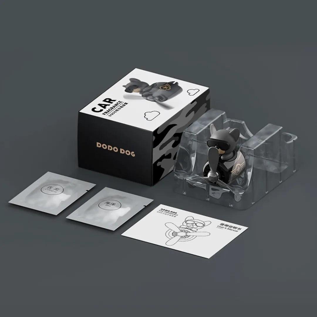 Dog Pilot Car Air Freshener packaging. Includes a cute propeller diffuser shaped like a dog pilot, two fragrance refills, and an instruction manual, all set against a dark background.
