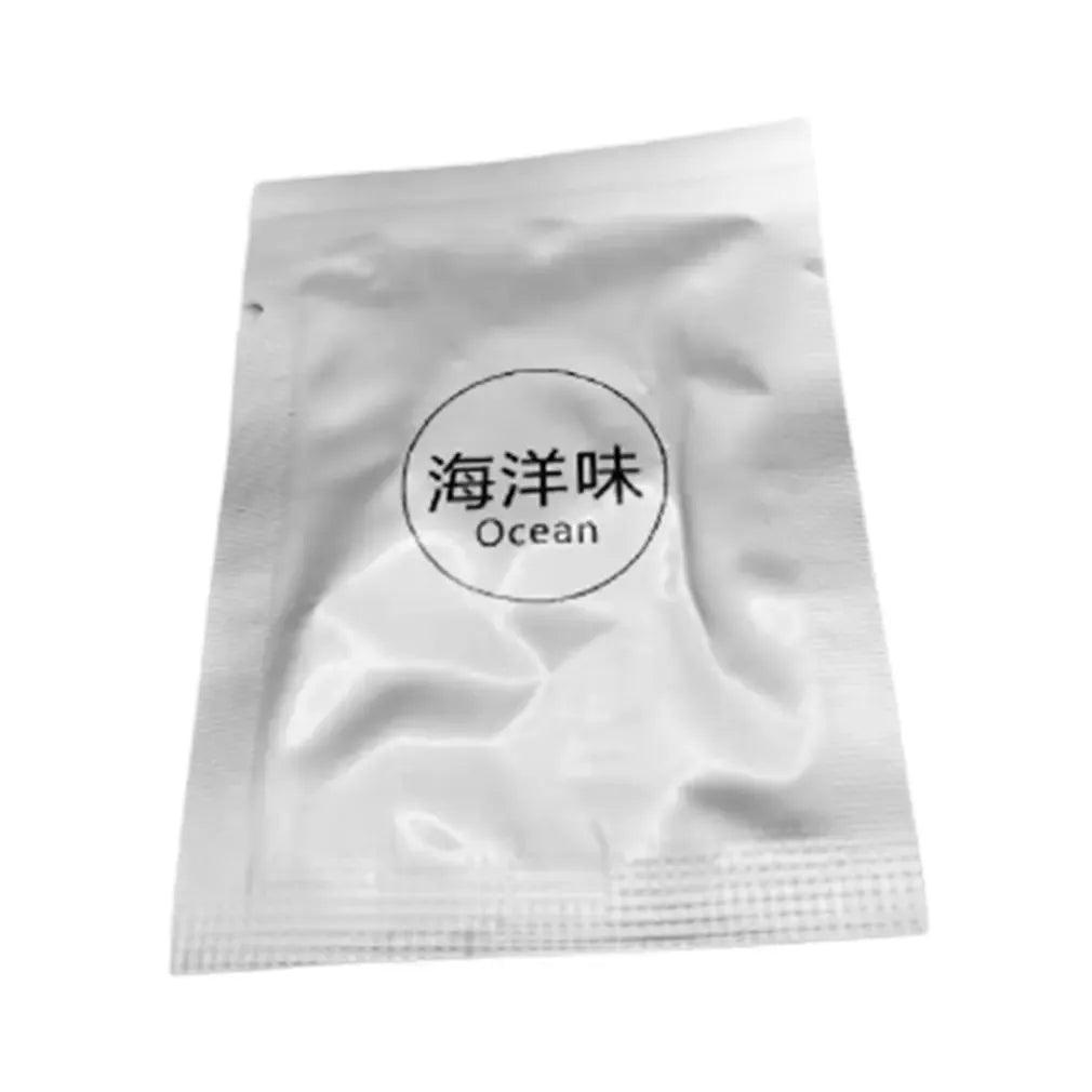 Individually packaged air freshener with an ocean scent in a silver foil packet labeled 'Ocean'.