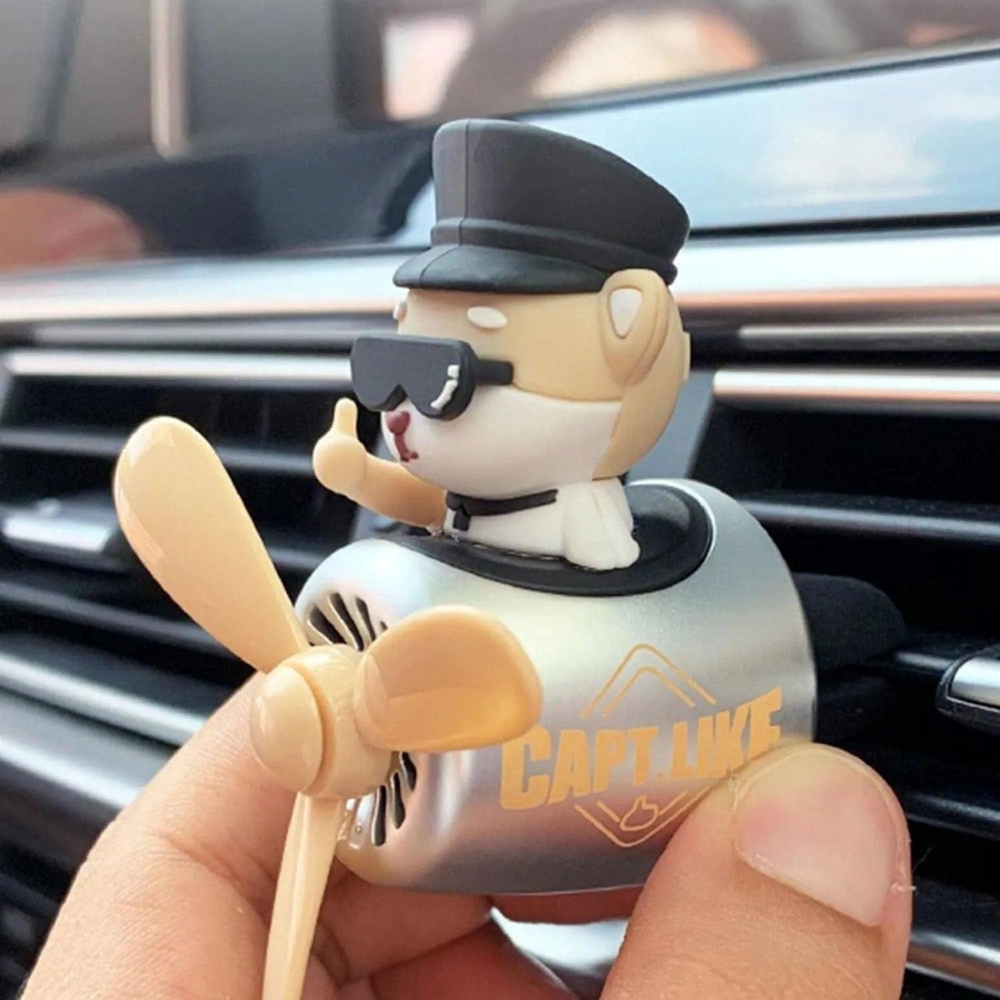 Shiba Inu pilot car air freshener with propeller diffuser being installed on a car air vent, highlighting the installation process.