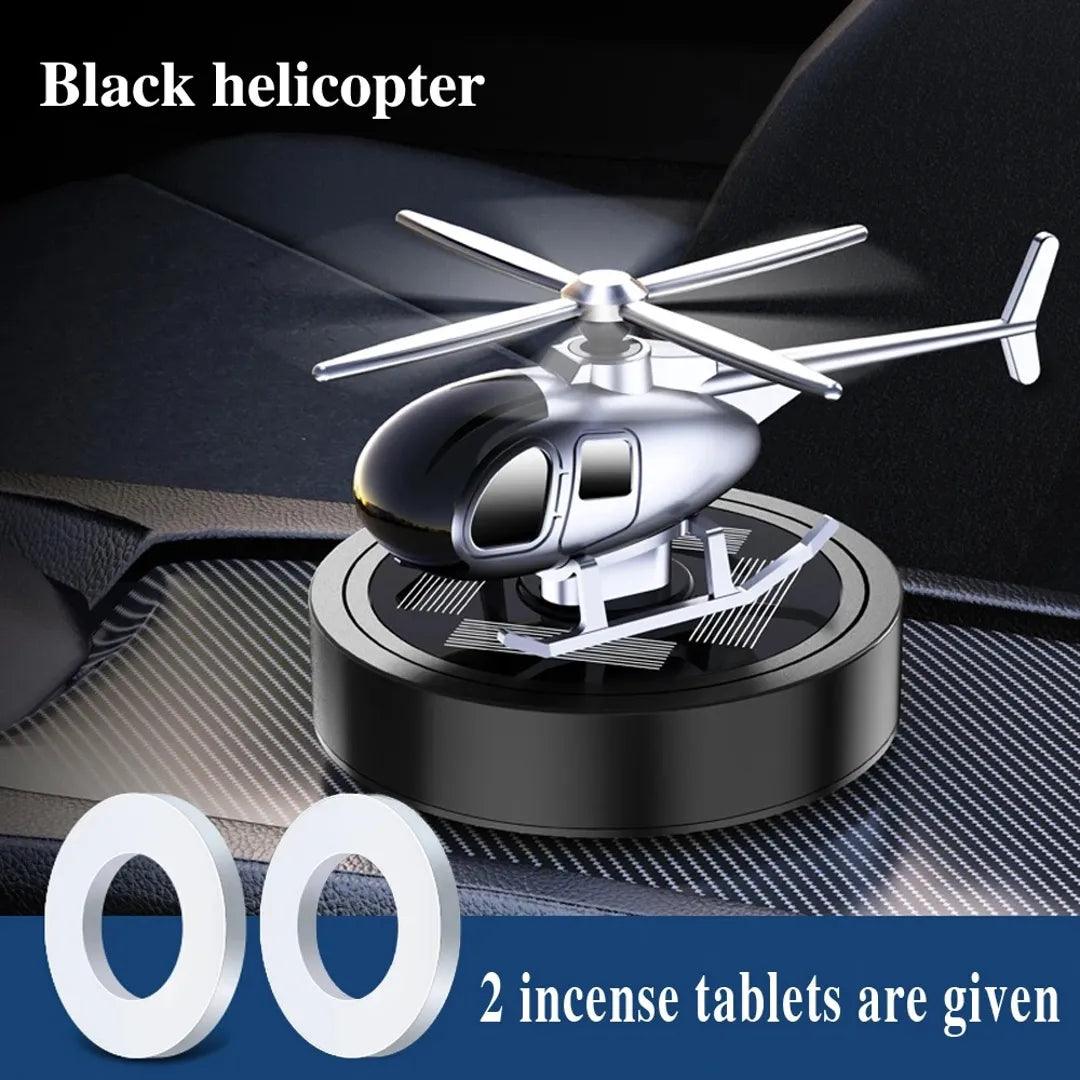 Solar-powered black helicopter propeller car air freshener with two incense tablets, providing a stylish and fragrant car interior accessory.