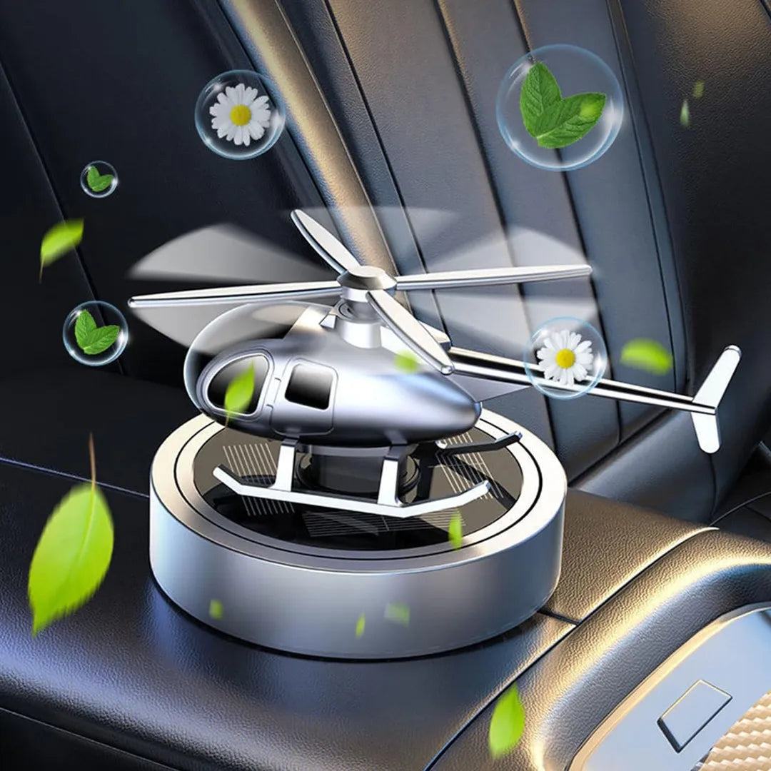 Solar-powered silver helicopter propeller car air freshener, releasing fresh fragrance in a car interior, providing a stylish and aromatic experience.