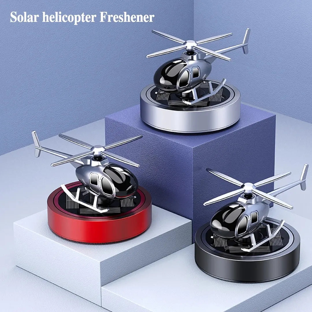 Set of solar-powered helicopter propeller car air fresheners in red, silver, and black colors, displayed on a podium, offering a stylish and efficient fragrance solution for vehicles.