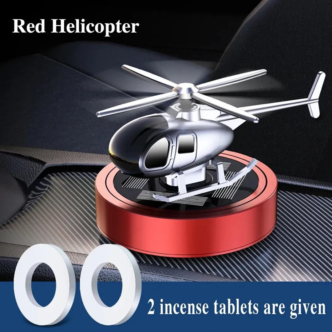 Solar-powered red helicopter propeller car air freshener with two incense tablets, designed for enhancing car interiors with a fresh fragrance.